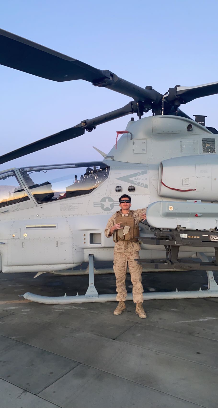Darvin Olguin in Marine Corps uniform standing beside a helicopter