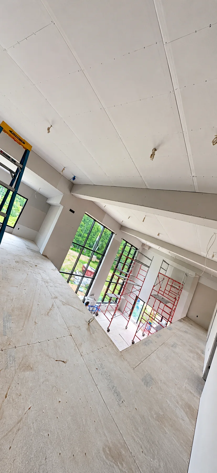 Drywall installation around a double-height interior